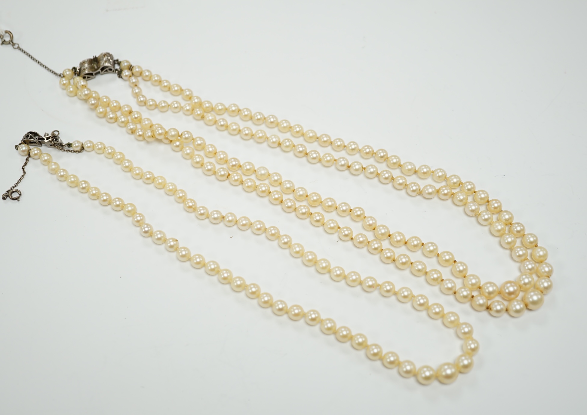 A double strand graduated cultured pearl necklace, with a white metal clasp, 48cm, together with a similar single strand graduated cultured pearl necklace